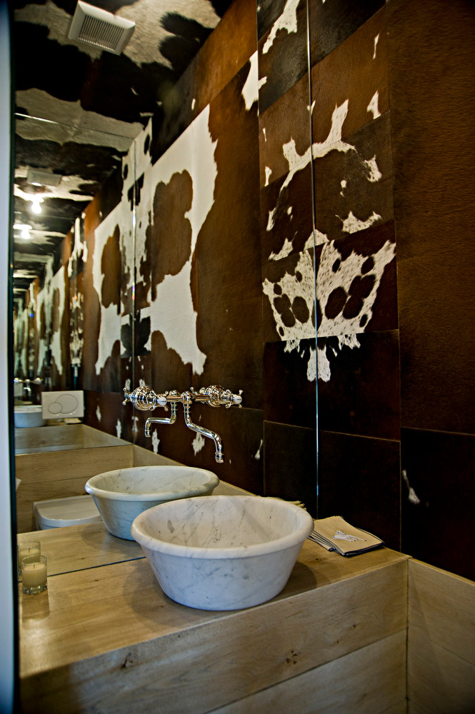 Powder room with cowhide walls, ceiling and mirror